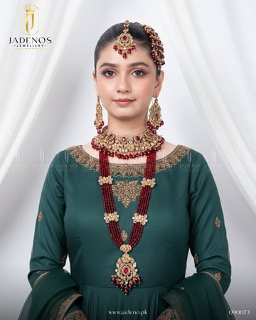 Model wearing Traditional Rangreza Bridal Set With Maala, Tika and Jhumar, featuring red beads, gold detailing, and bridal elegance