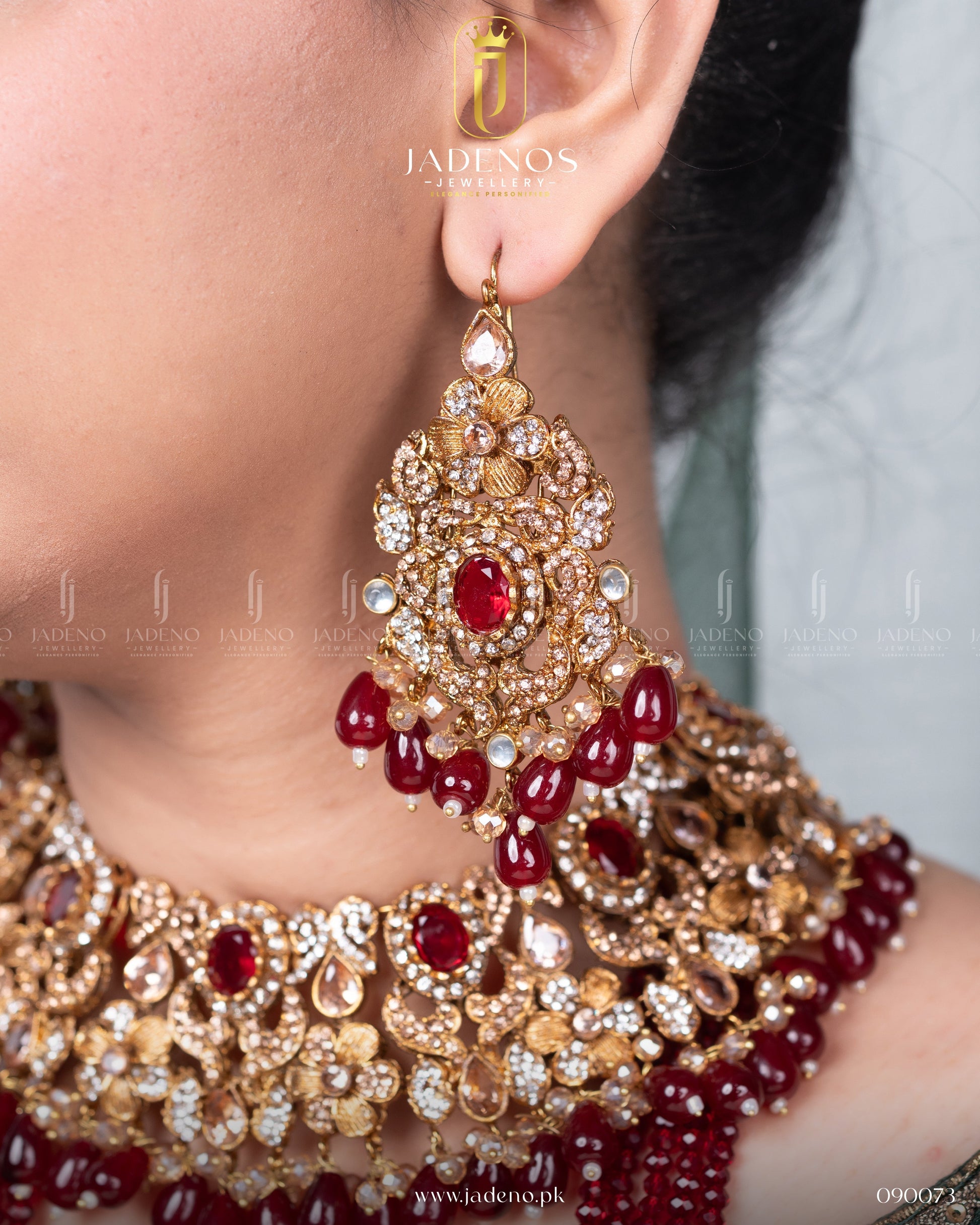Close-up of Traditional Rangreza Bridal Set With Maala, Tika and Jhumar earrings with red stones and gold detailing