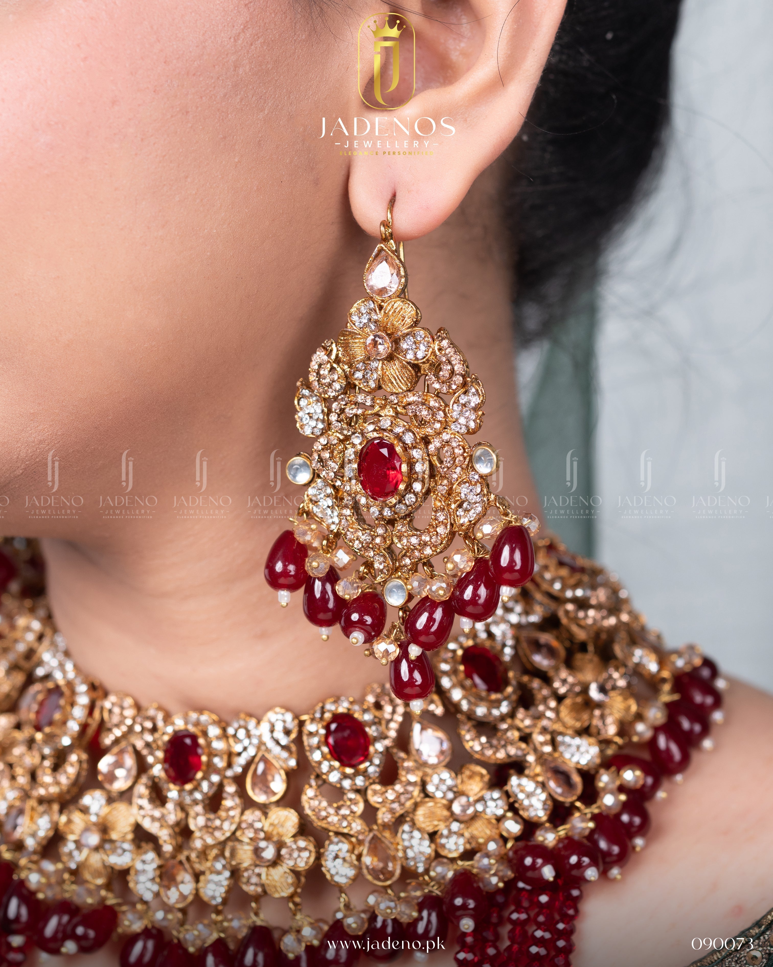 Close-up of Traditional Rangreza Bridal Set With Maala, Tika and Jhumar earrings with red stones and gold detailing