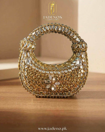 The Glided Empress Clutch with gold finish, embellished with stones and intricate detailing in a structured handbag design