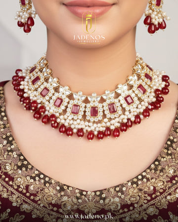 Bridal model wearing Sultana Edit choker set with tika, gold choker necklace with red stones and pearl drops.