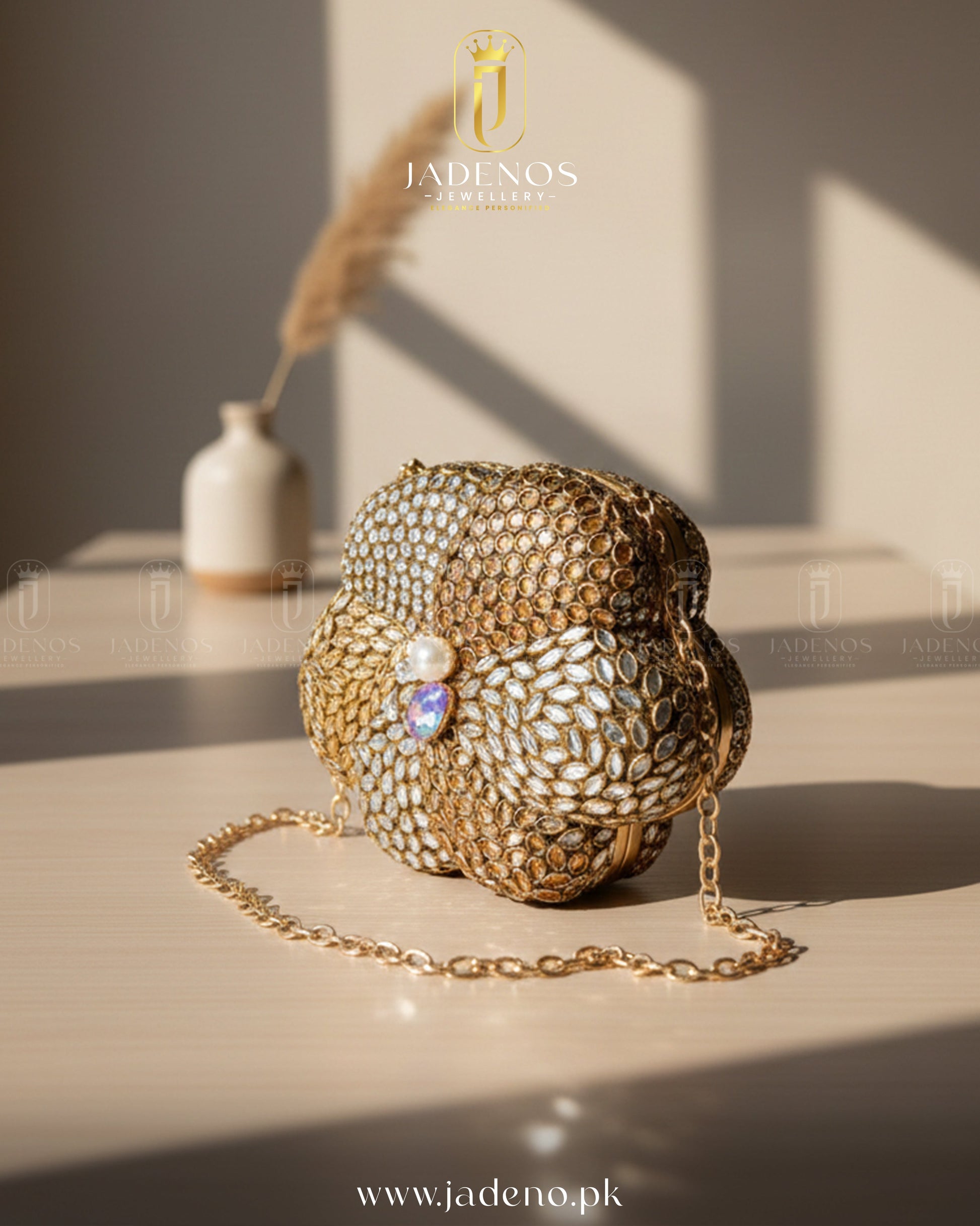 The Scarlet Core Clutch featuring gold floral craftsmanship, crystal detailing, pearl centerpiece, and chain strap in warm natural light